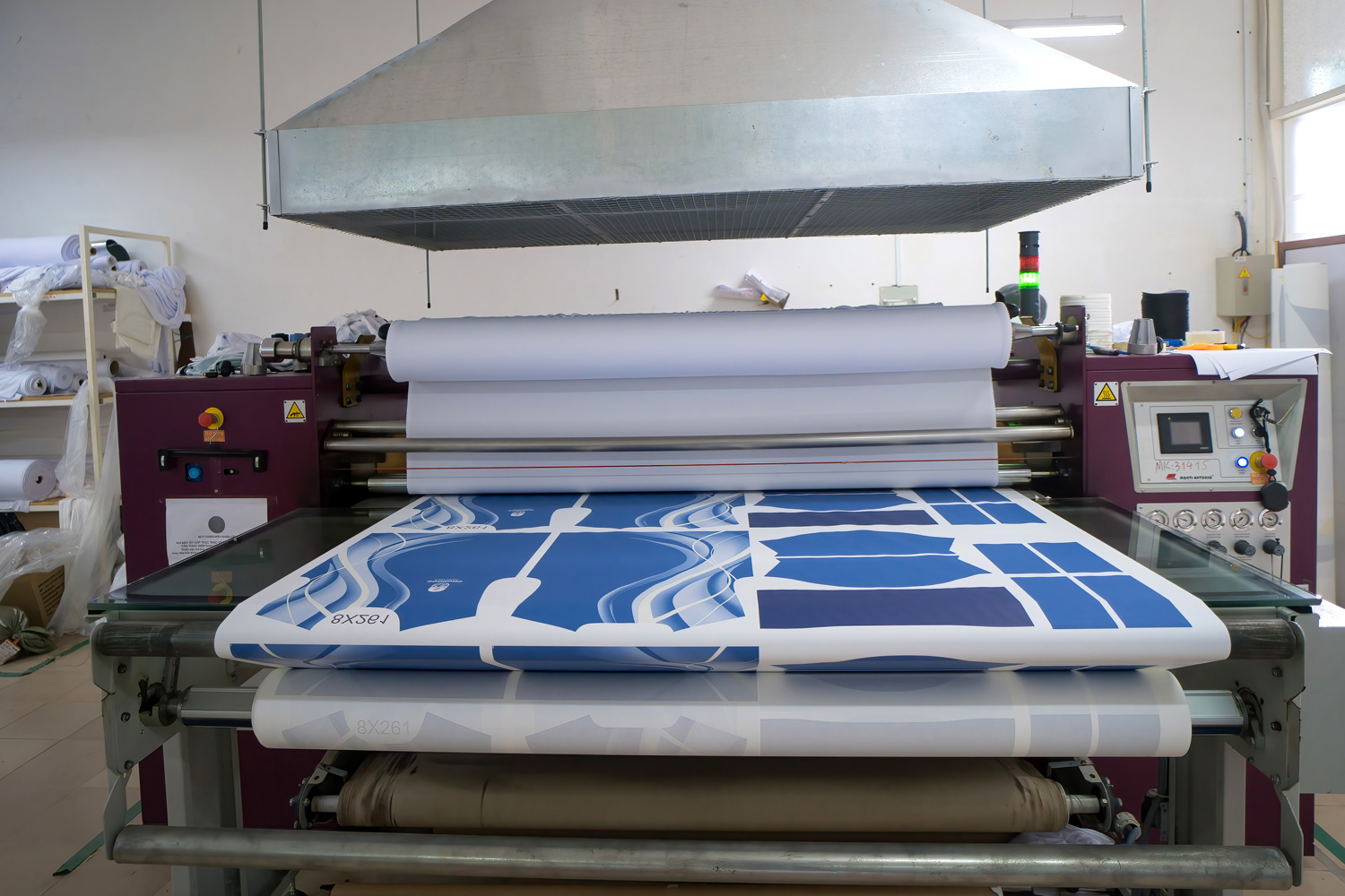 Heat transfer machine transferring print from paper to fabric for custom apparel.