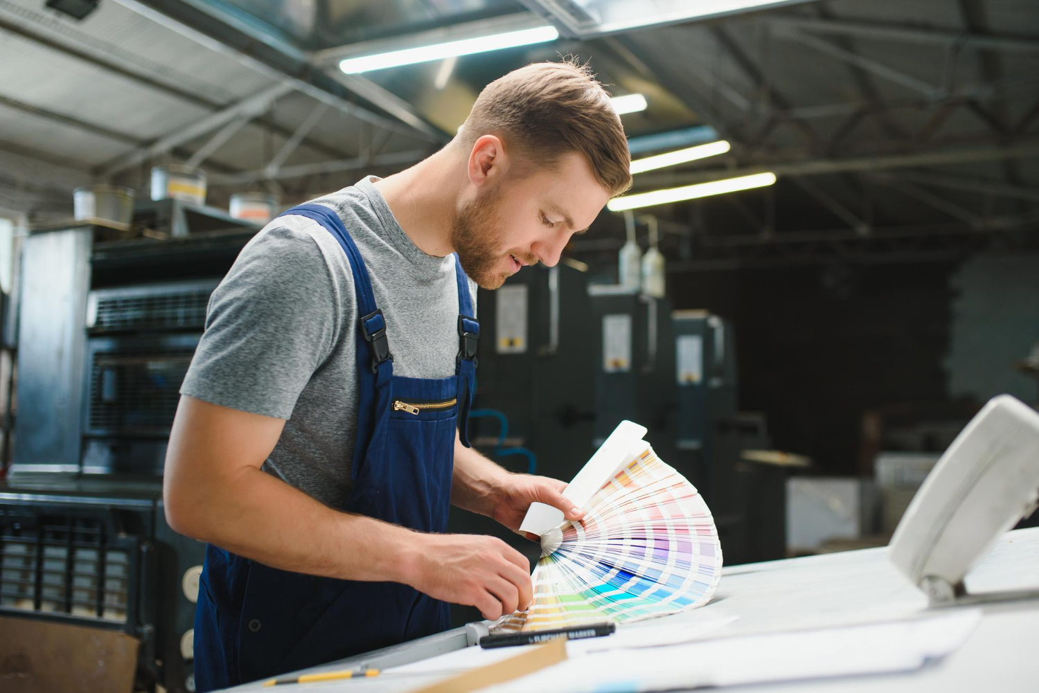 Man checking colors in a Pantone color book for sublimation sportswear.