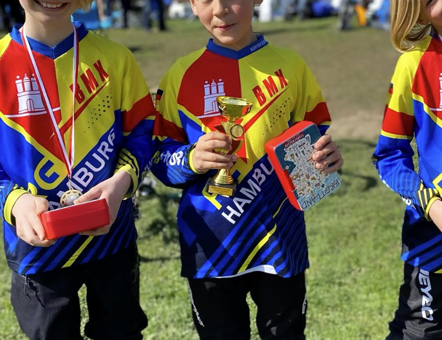 Three kids from RG Hamburg BMX team wearing their custom Lightforce Kids jerseys for BMX racing.