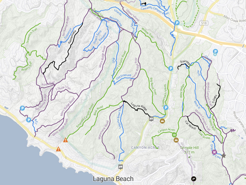 A scenic view of mountain bike trails winding through the rolling hills of Laguna Coast Wilderness Park, surrounded by coastal sage scrub and open sky.