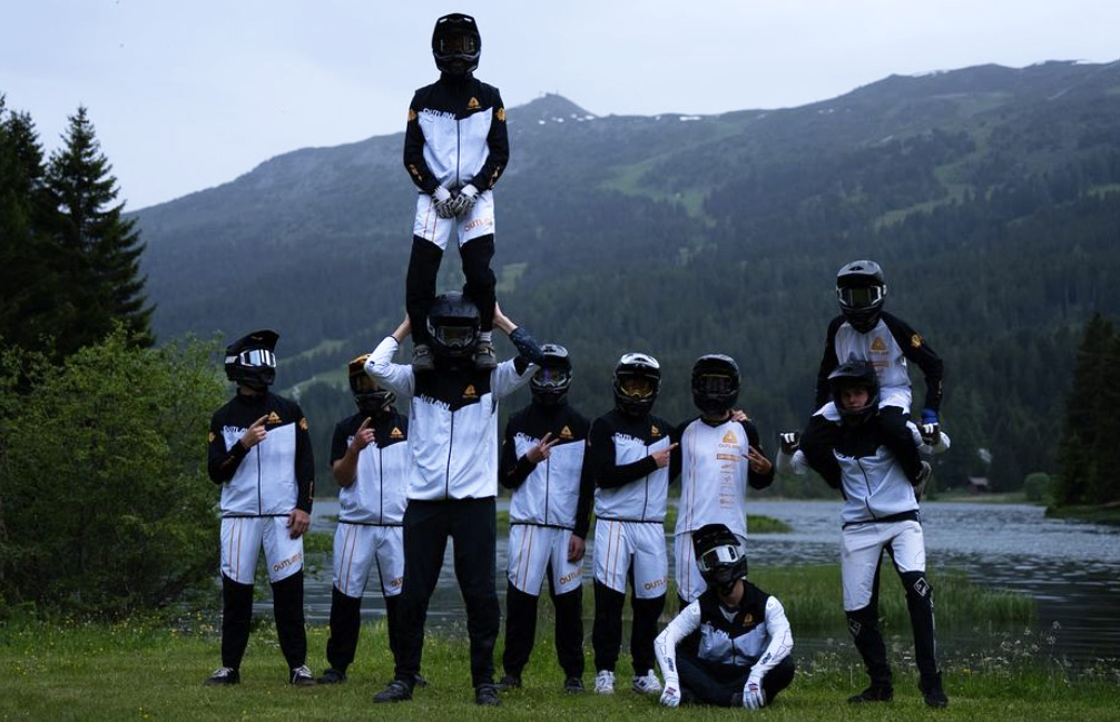 Outlaw MTB team photo with all riders wearing the white version of their custom MTB kit, wind vest, and joggers.