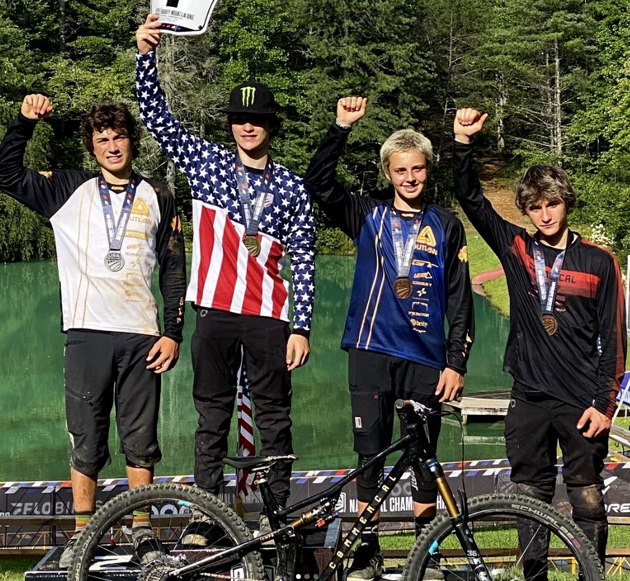 Two Outlaw MTB riders on the podium, wearing the brand new custom-designed 2024 MTB jerseys.