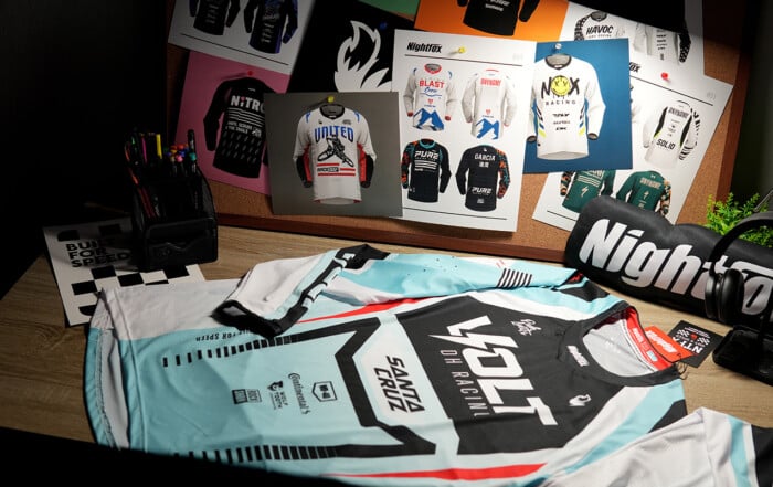 Finished Nightfox custom DH jersey laid flat on a table after quality check, ready for delivery to VOLT DH Racing USA; full‑sublimation, long‑sleeve, slim‑fit design.